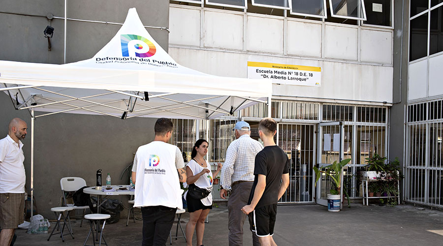 Personal de la Defensoría presente en la entrada de una escuela de educación media