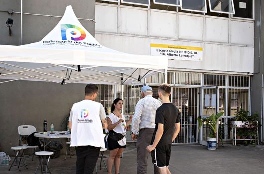 Personal de la Defensoría presente en la entrada de una escuela de educación media