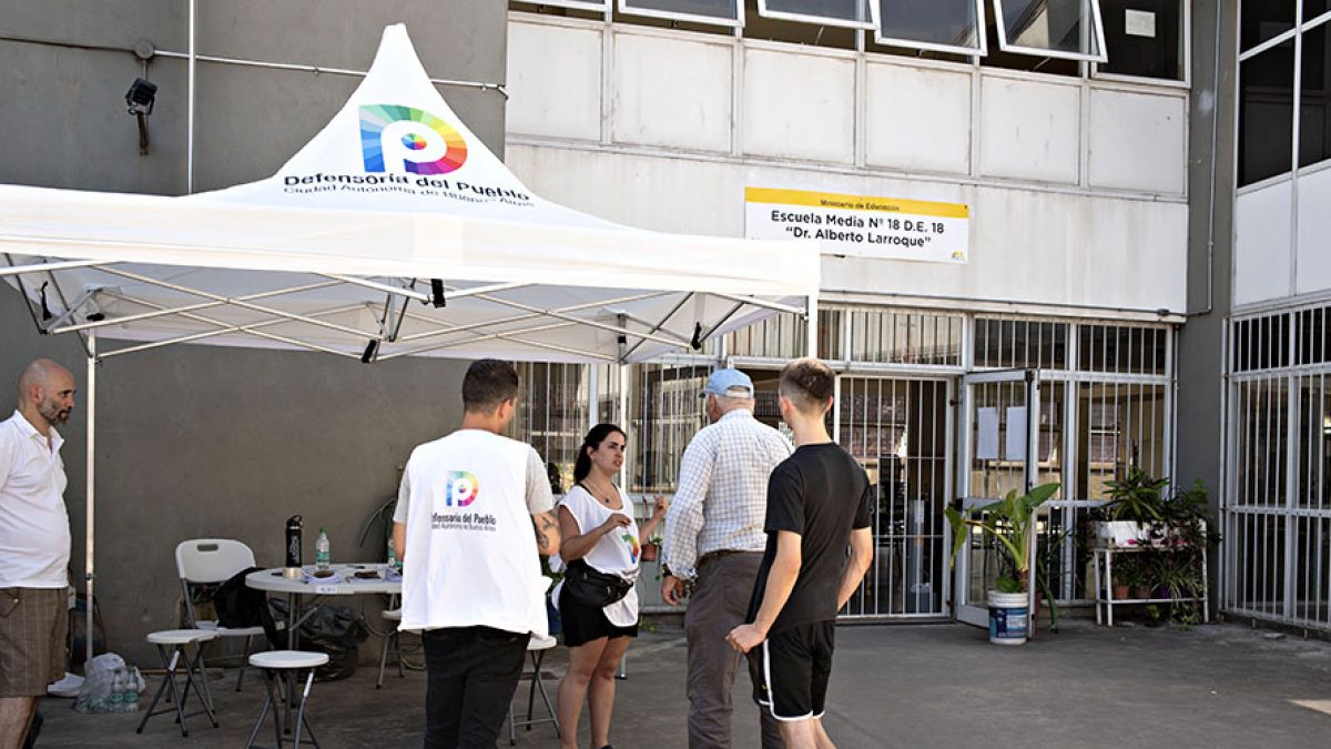 Personal de la Defensoría presente en la entrada de una escuela de educación media