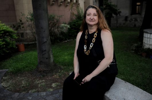 La defensora María Rosa Muiños sentada en un espacio verde