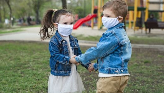 Child boy and girl walking outdoors with face mask protection. Coronavirus, covid-19